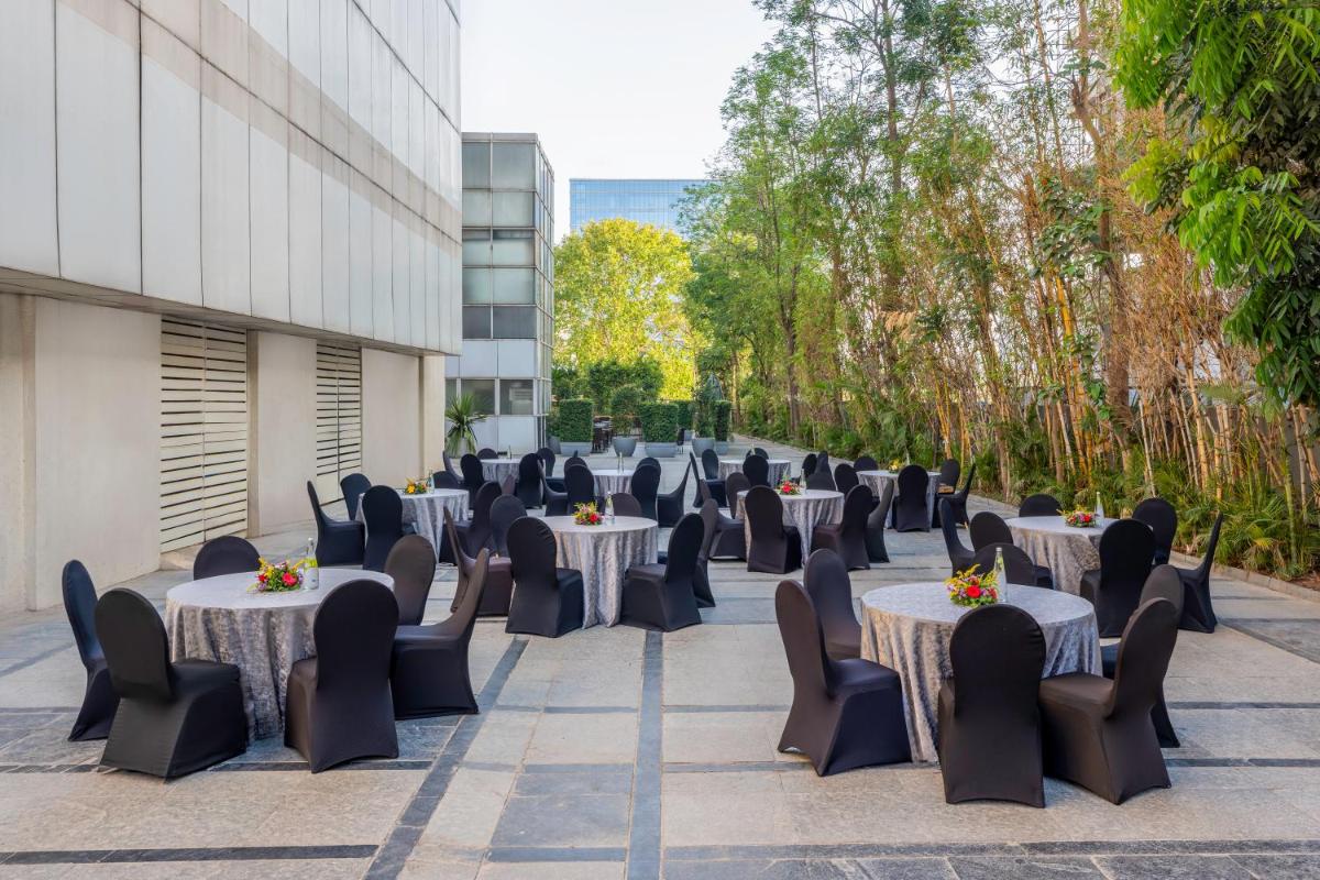 a row of tables and chairs in front of a building at Radisson Blu Hotel Pune Kharadi in Pune