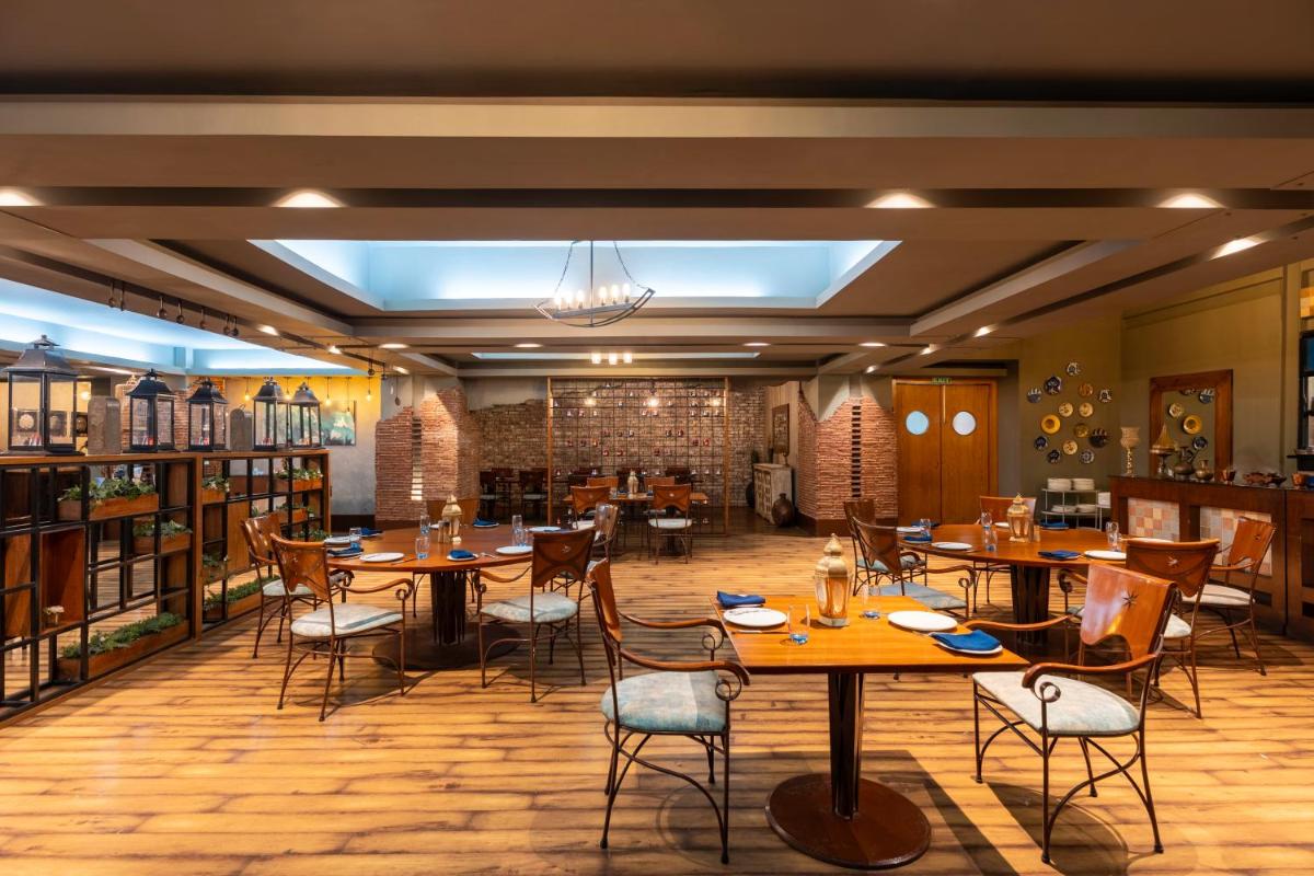 a restaurant with tables and chairs in a room at Radisson Blu Hotel Pune Kharadi in Pune
