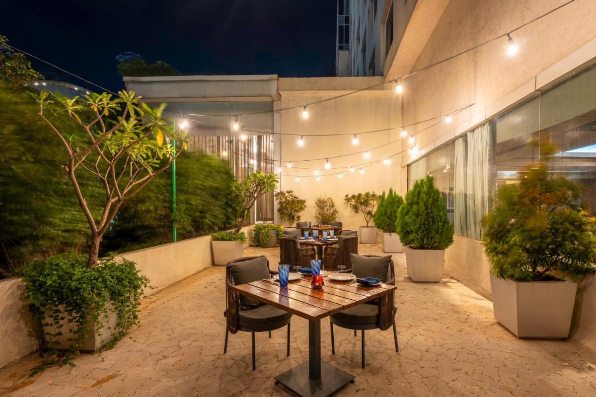 a patio with a table and chairs and a building at Radisson Blu Hotel Pune Kharadi in Pune