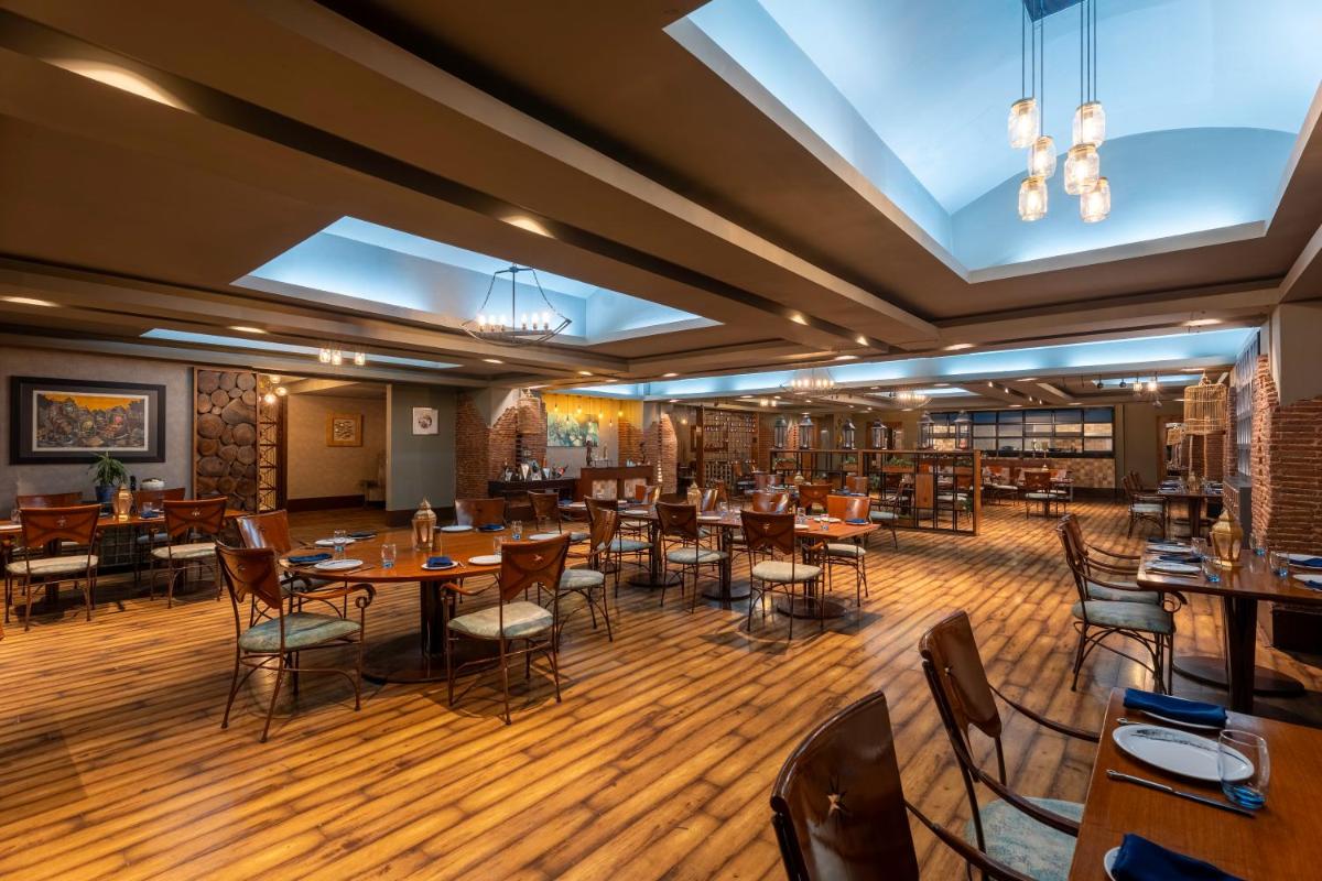 a restaurant with wooden floors and tables and chairs at Radisson Blu Hotel Pune Kharadi in Pune