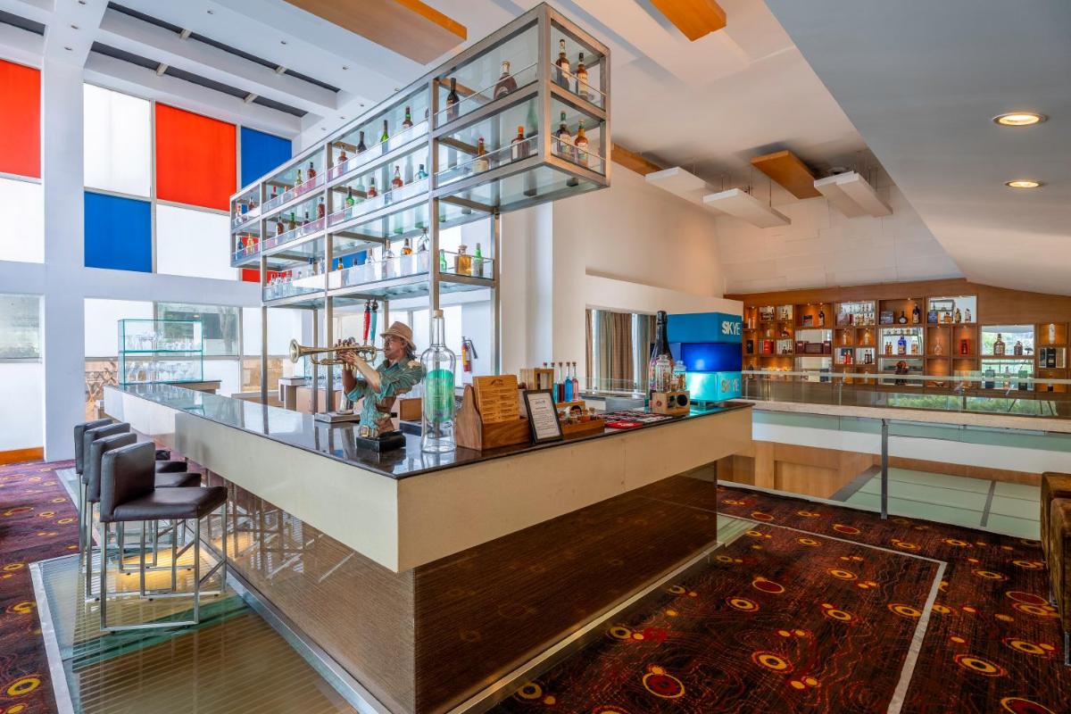 a restaurant with a counter and a bar with chairs at Radisson Blu Hotel Pune Kharadi in Pune
