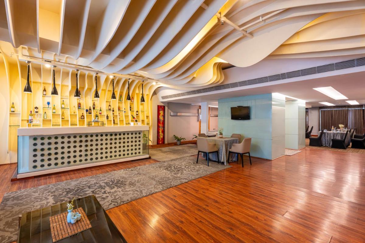 a lobby with a bar and a table with chairs at Radisson Blu Hotel Pune Kharadi in Pune