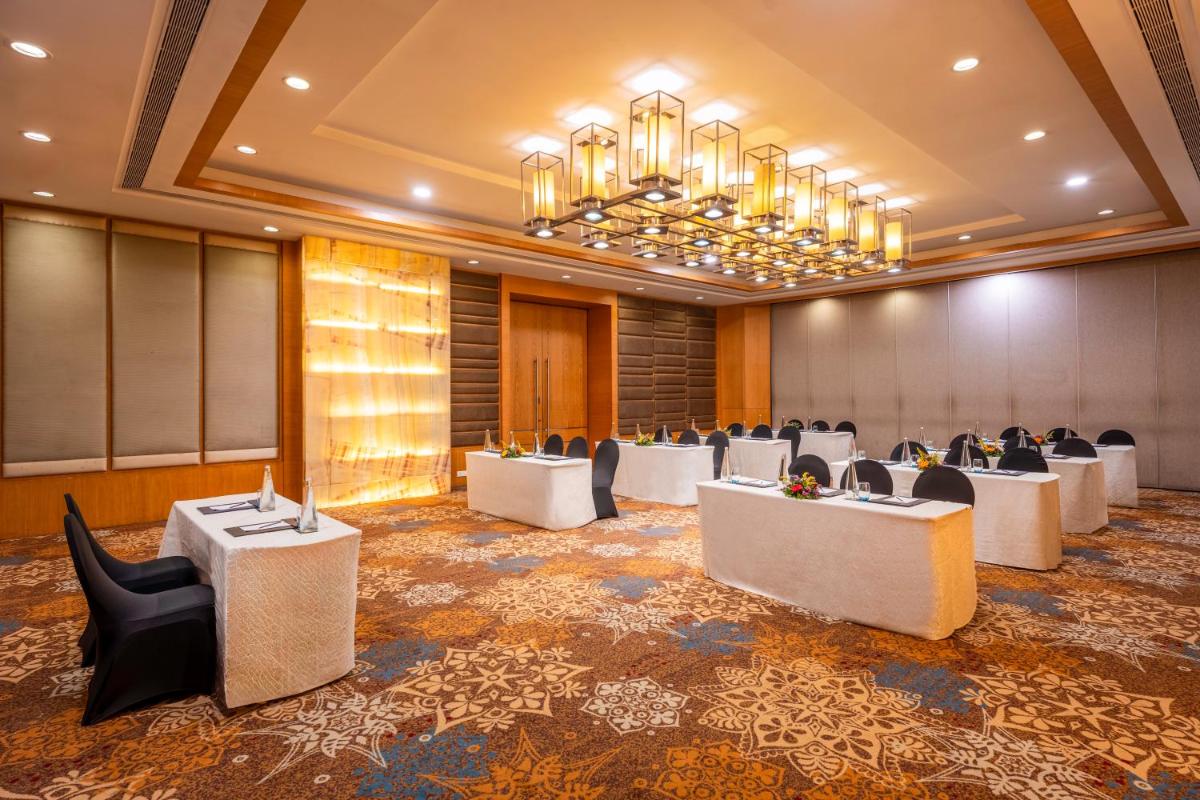 a conference room with white tables and chairs at Radisson Blu Hotel Pune Kharadi in Pune
