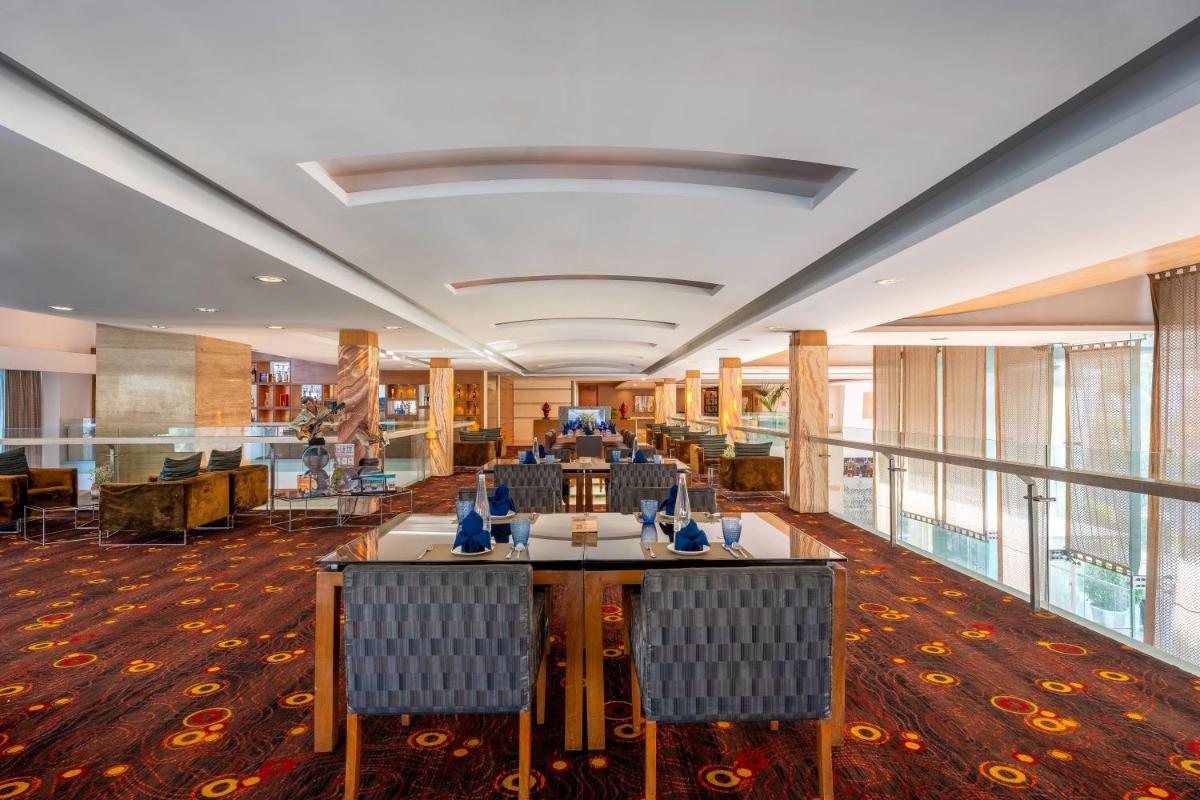 a conference room with tables and chairs in a building at Radisson Blu Hotel Pune Kharadi in Pune
