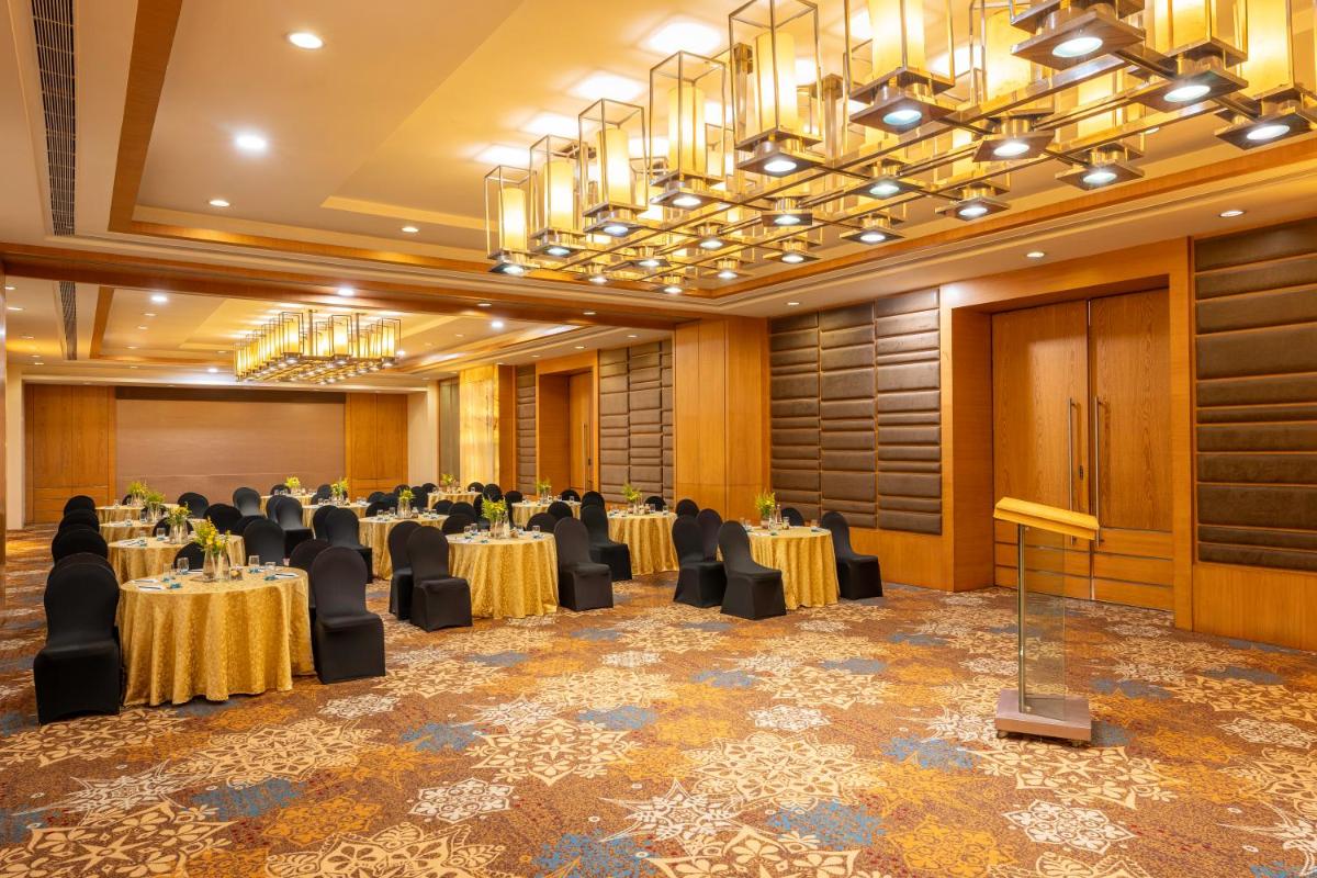 a banquet hall with tables and chairs in a room at Radisson Blu Hotel Pune Kharadi in Pune
