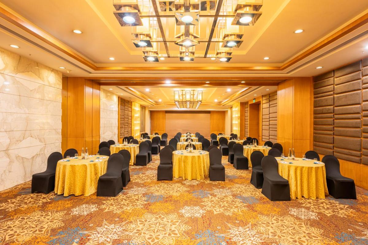 a banquet hall with tables and chairs in a room at Radisson Blu Hotel Pune Kharadi in Pune