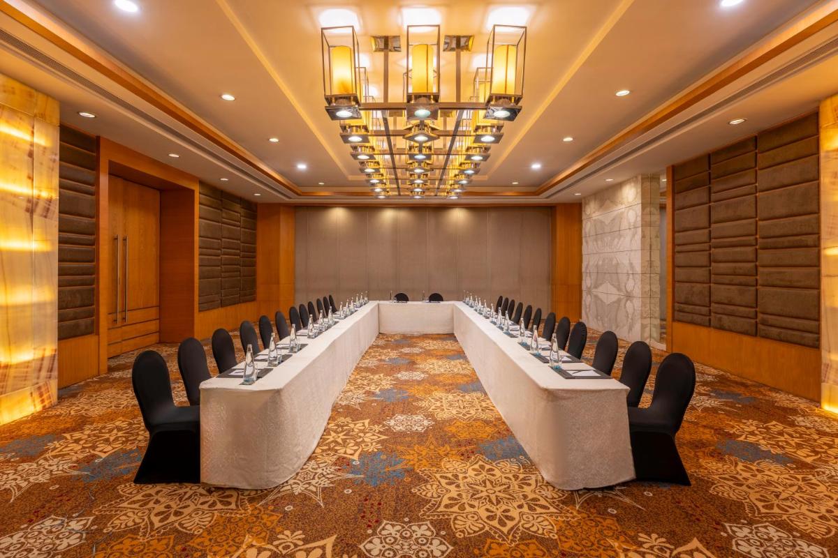a conference room with a row of tables and chairs at Radisson Blu Hotel Pune Kharadi in Pune