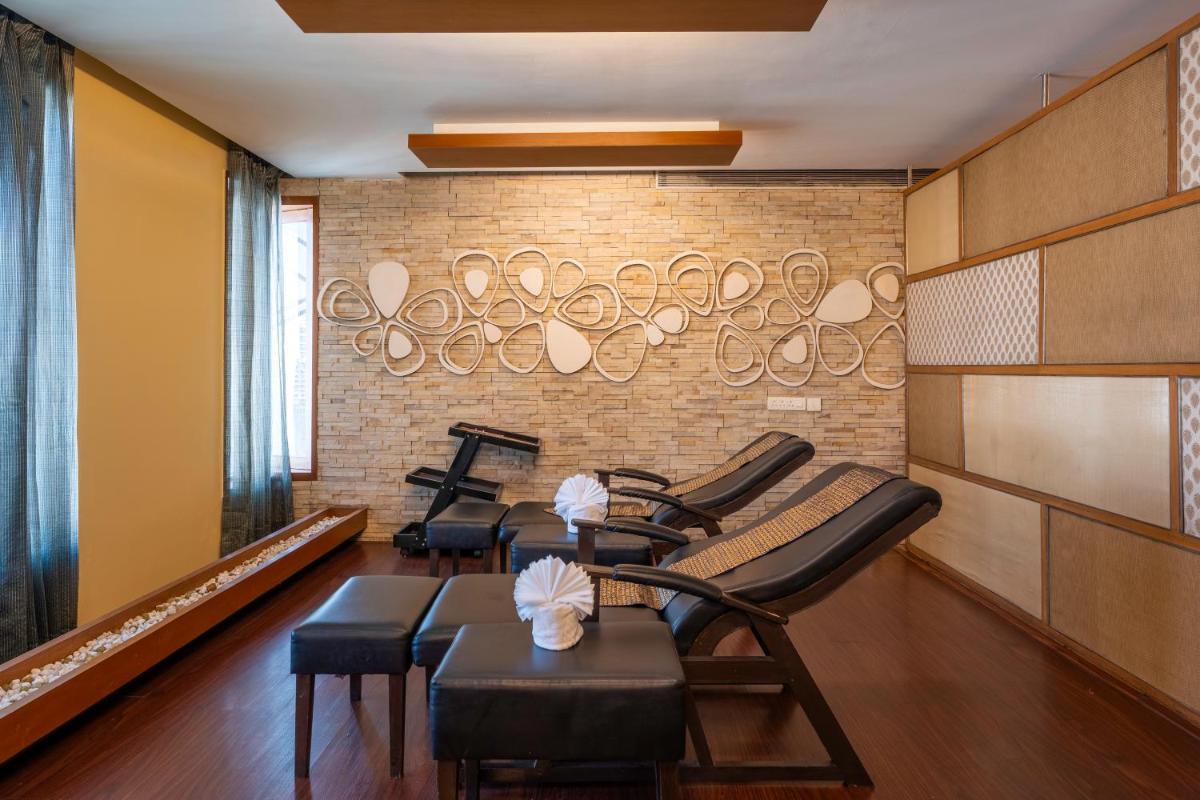 a waiting room with chairs and tables and a brick wall at Radisson Blu Hotel Pune Kharadi in Pune