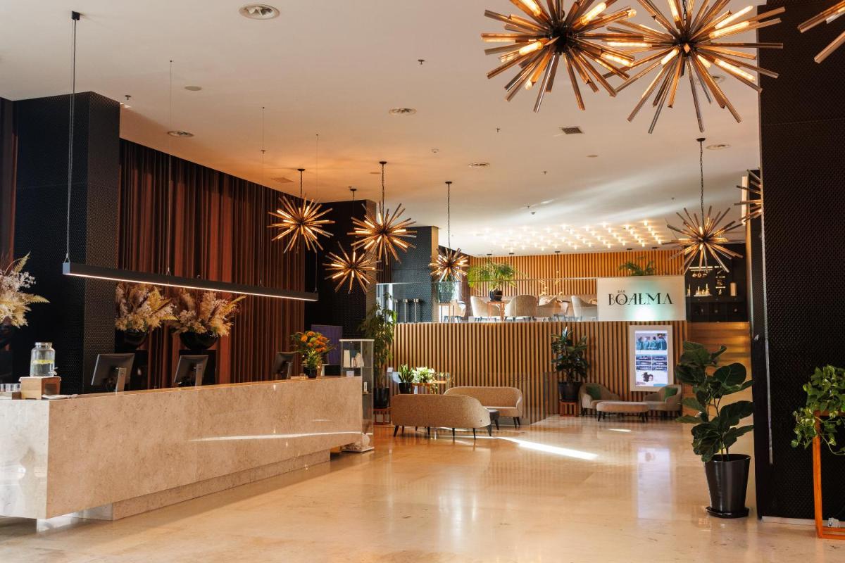 um saguão de um restaurante com mesas e cadeiras em Iberostar Selection Lisboa em Lisboa