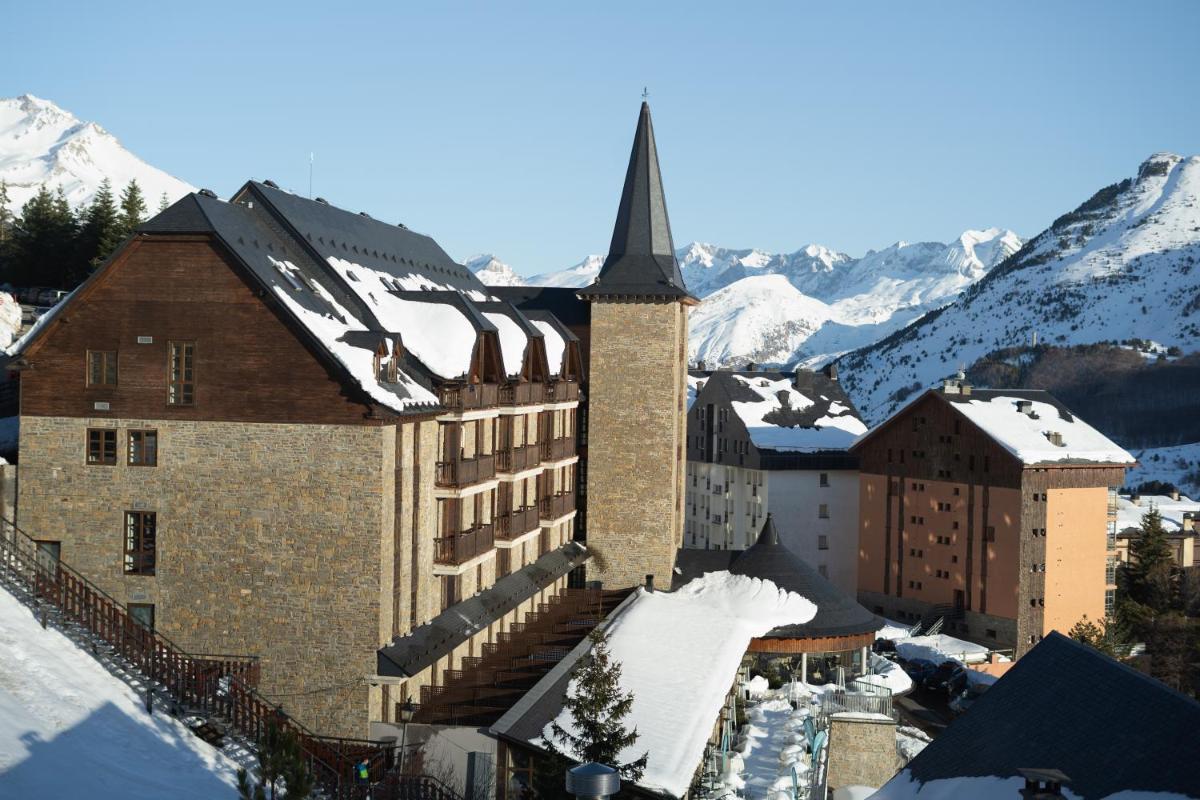 Un gran edificio con un campanario en la nieve. en Snö Aragon Hills, en Formigal