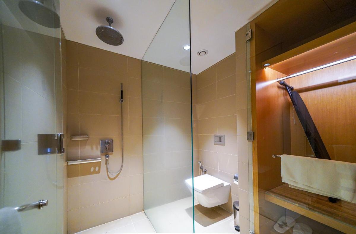 a bathroom with a shower with a sink and a toilet at BLVD Club - Near BENGALURU AIRPORT in Bengaluru