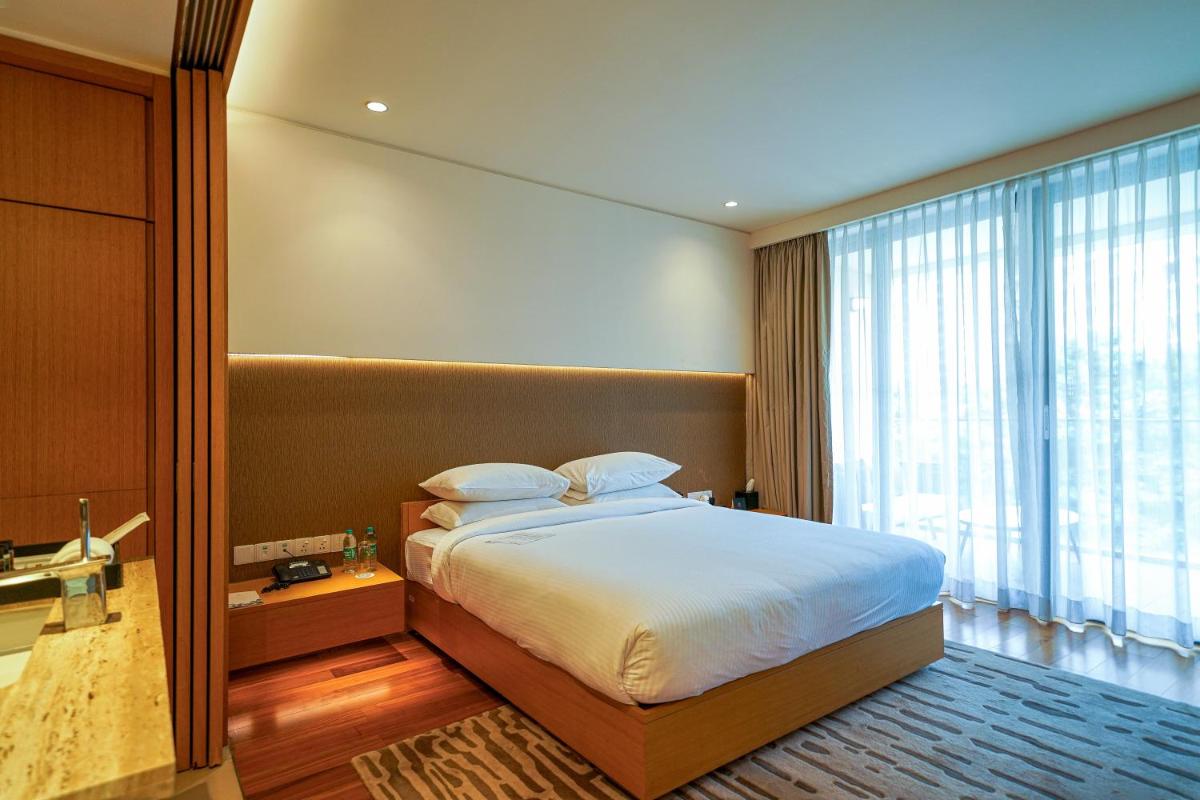 a bedroom with a bed and a large window at BLVD Club - Near BENGALURU AIRPORT in Bengaluru