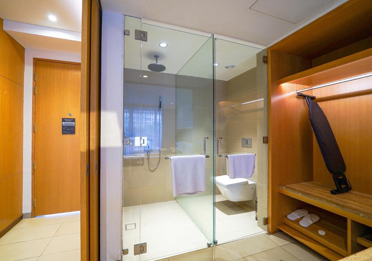 a bathroom with a glass shower and a toilet at BLVD Club - Near BENGALURU AIRPORT in Bengaluru