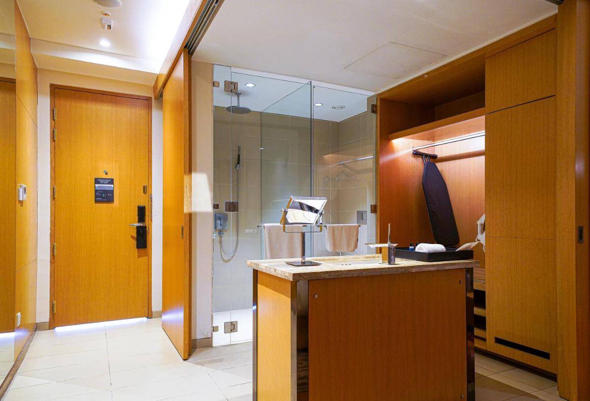 a bathroom with a shower and a sink and a mirror at BLVD Club - Near BENGALURU AIRPORT in Bengaluru
