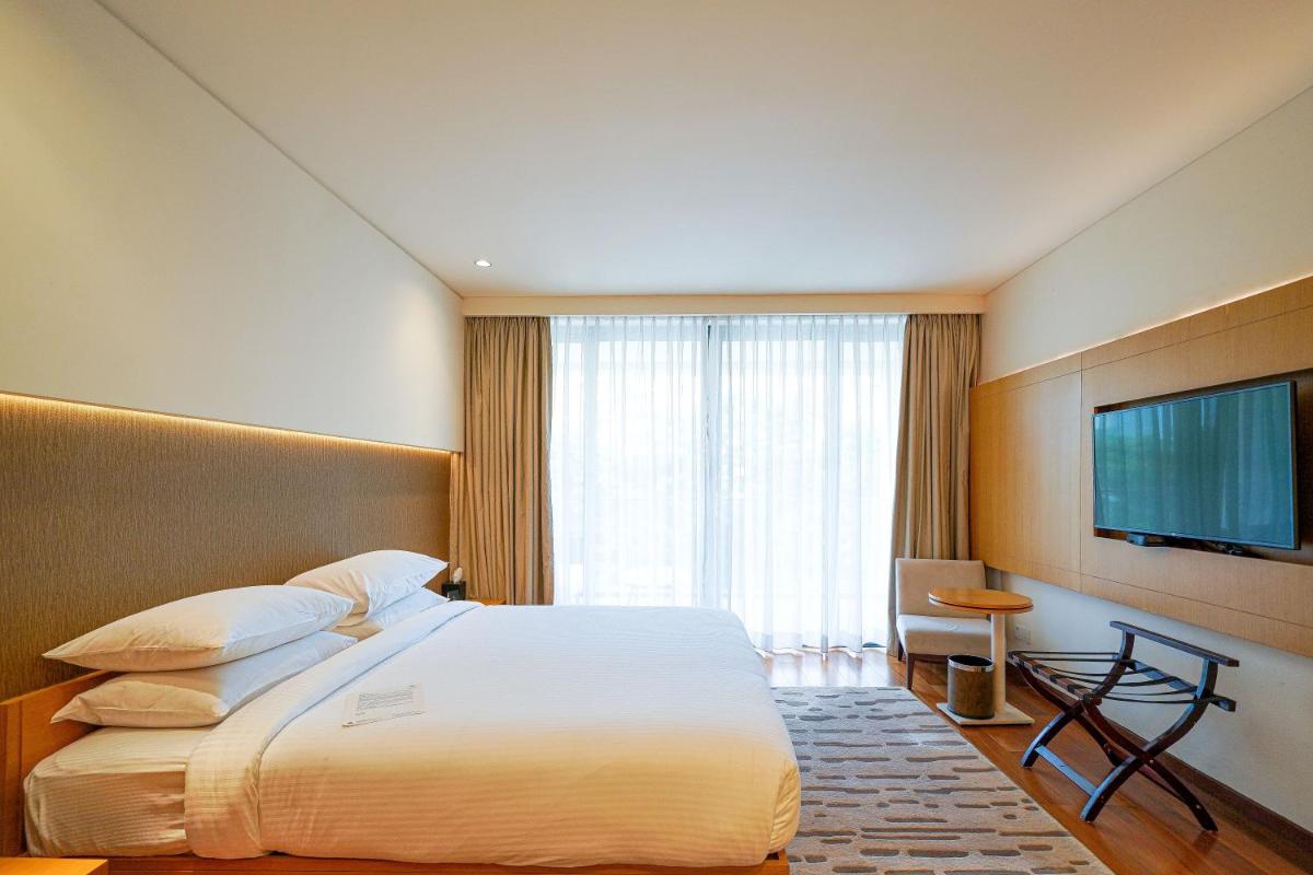 a hotel room with a bed and a flat screen tv at BLVD Club - Near BENGALURU AIRPORT in Bengaluru