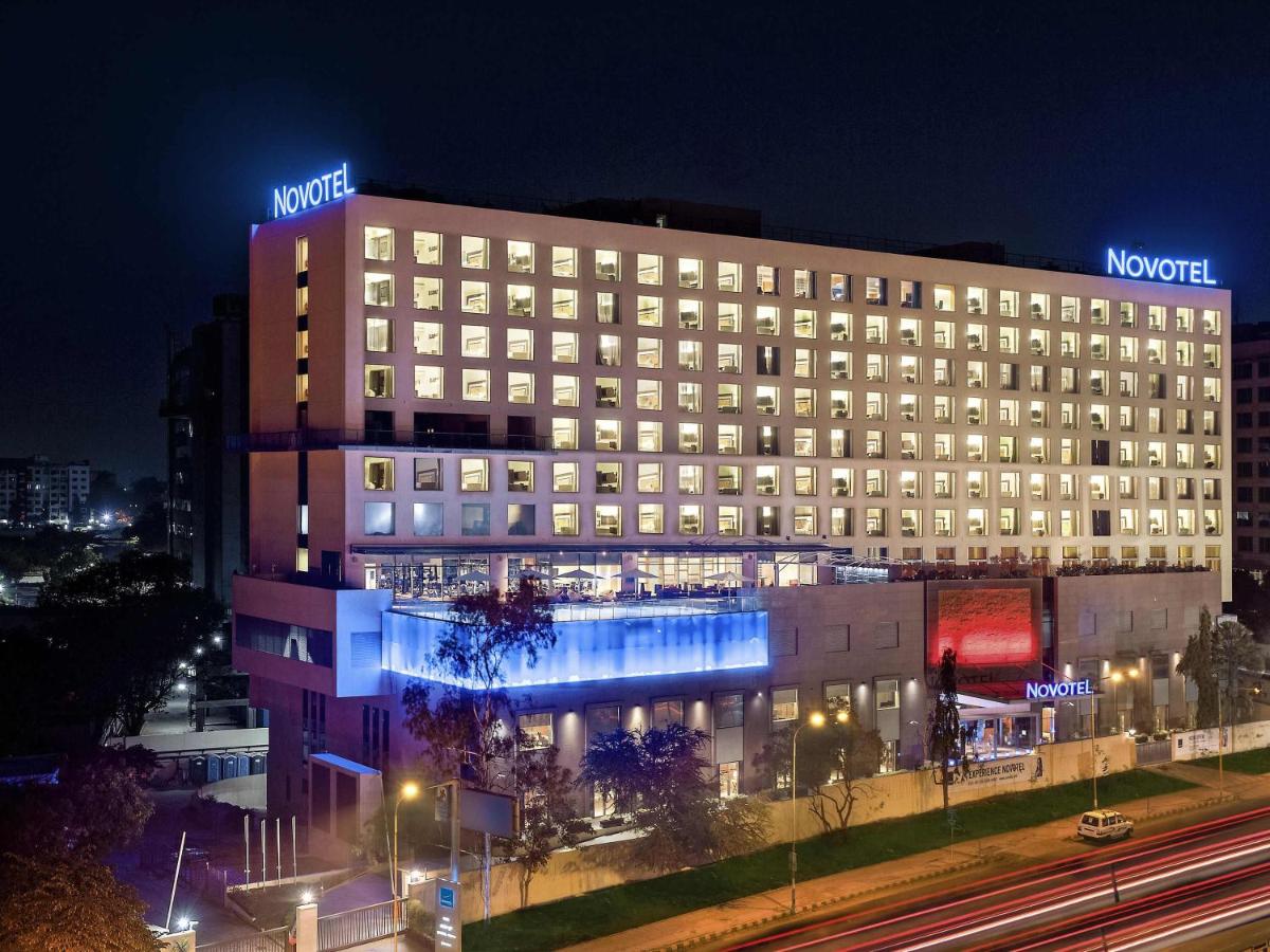 a hotel with a lit up building at night at Novotel Pune Viman Nagar Road in Pune