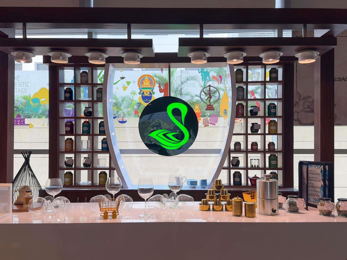 a table with wine glasses and a sign on a window at Novotel Pune Viman Nagar Road in Pune