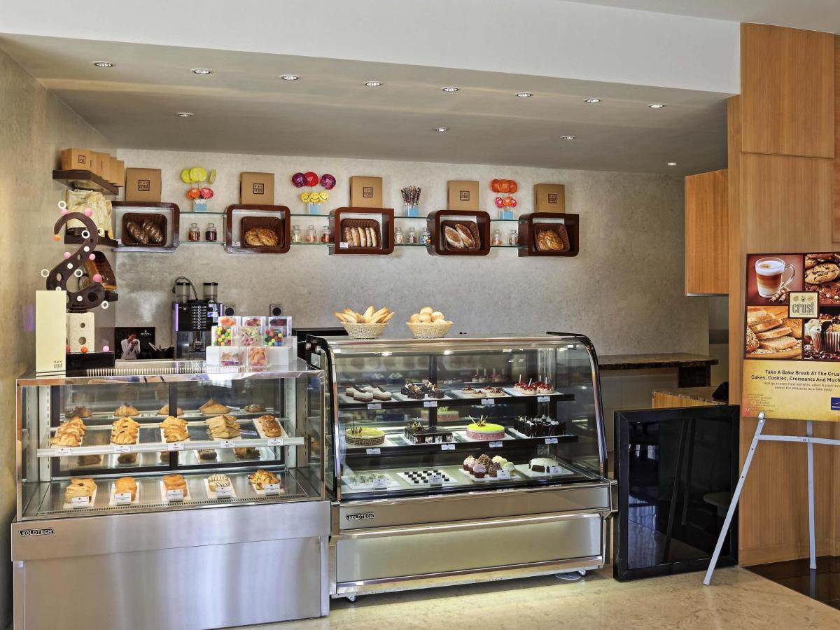 a bakery with a display case filled with pastries at Novotel Pune Viman Nagar Road in Pune