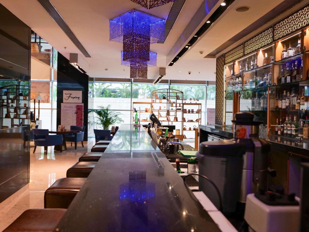a bar with a long counter in a restaurant at Novotel Pune Viman Nagar Road in Pune