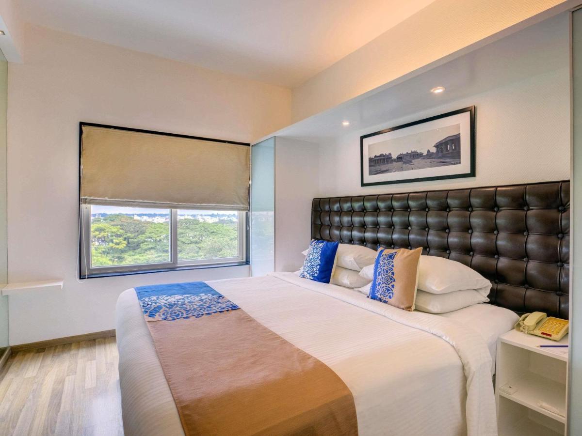 a bedroom with a large bed with a leather headboard at Grand Mercure Bangalore - An Accor Brand in Bengaluru