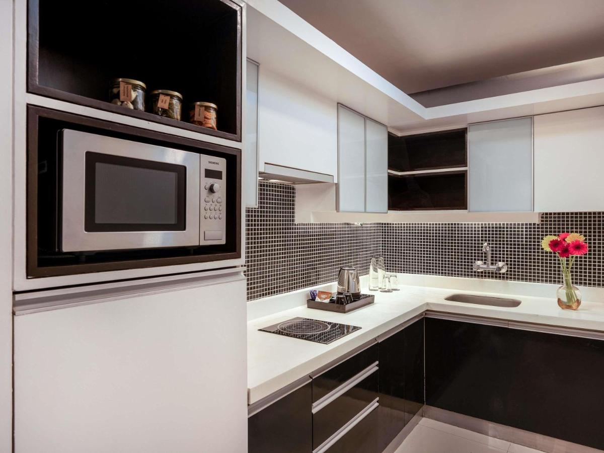 a kitchen with a microwave oven and a sink at Grand Mercure Bangalore - An Accor Brand in Bengaluru