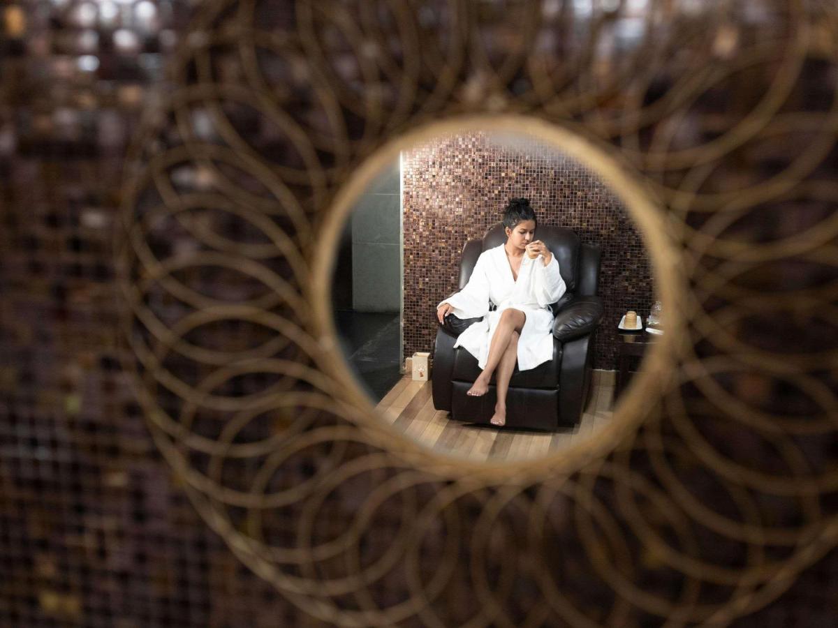 a woman sitting in a chair talking on a cell phone at Grand Mercure Bangalore - An Accor Brand in Bengaluru