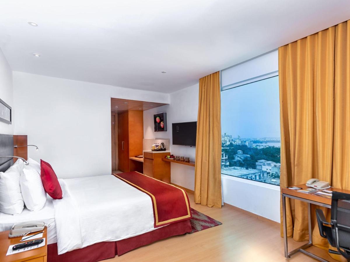 a hotel room with a bed and a large window at Mercure Hyderabad KCP Banjara Hills, An Accor Hotel in Hyderabad