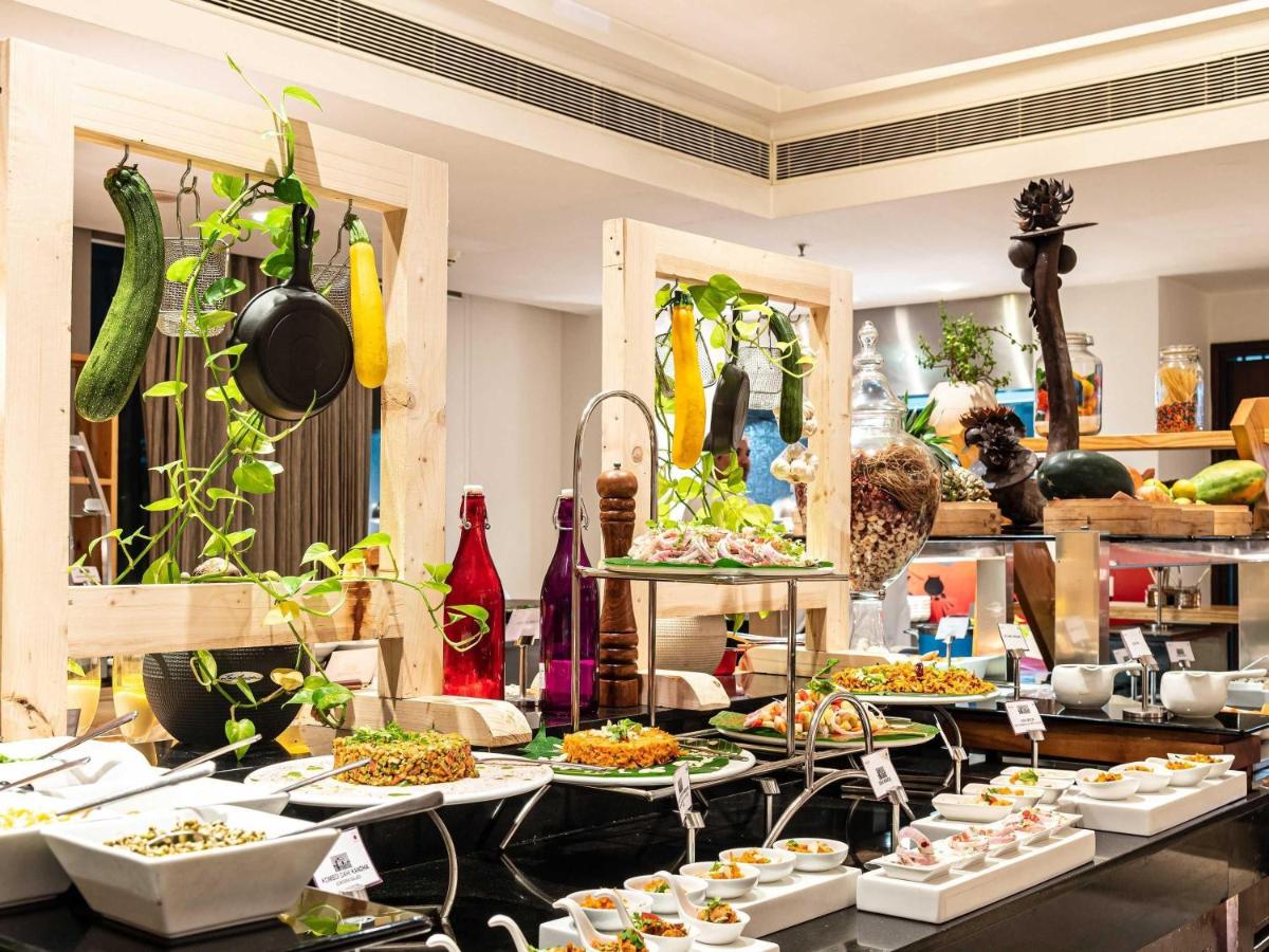 a buffet with plates of food on a table at Mercure Hyderabad KCP Banjara Hills, An Accor Hotel in Hyderabad