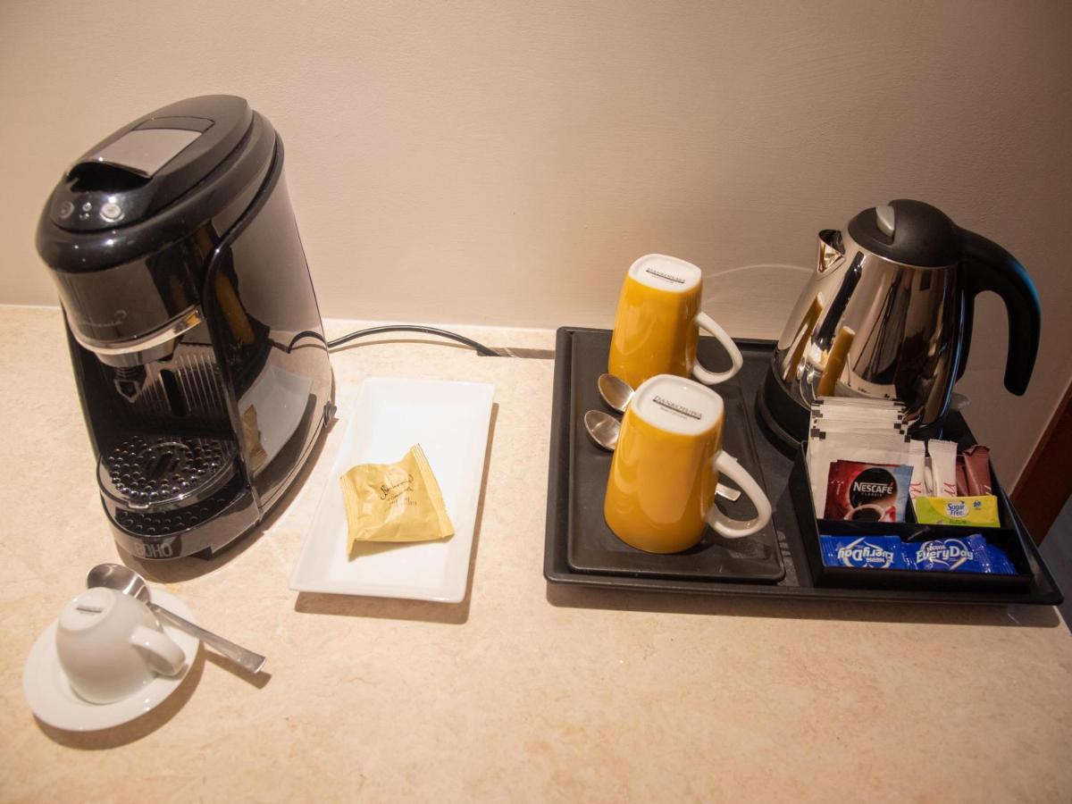 a counter top with a coffee maker and affeepot and a coffee pot at Mercure Hyderabad KCP Banjara Hills, An Accor Hotel in Hyderabad