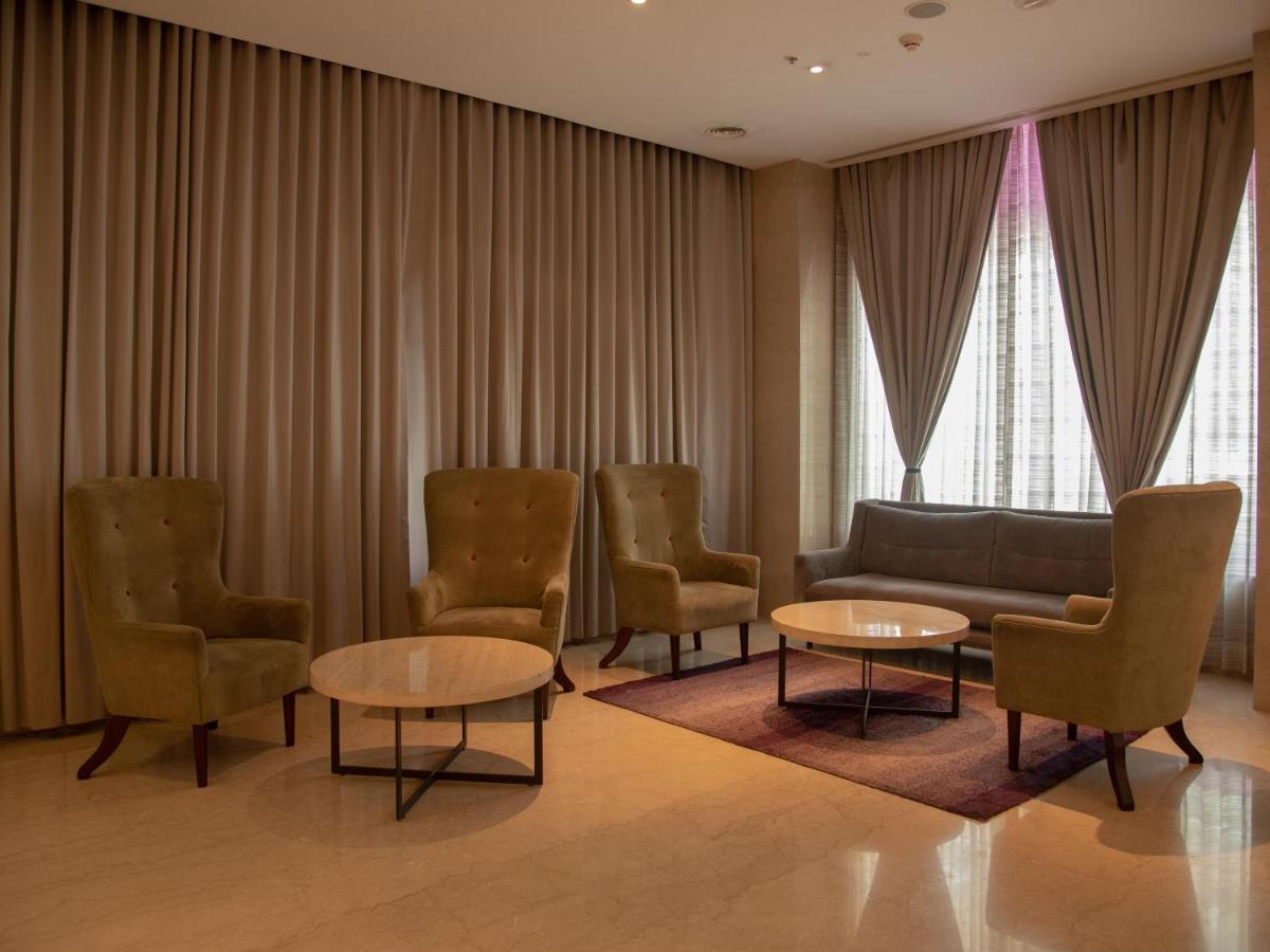 a waiting room with chairs and a couch and tables at Mercure Hyderabad KCP Banjara Hills, An Accor Hotel in Hyderabad