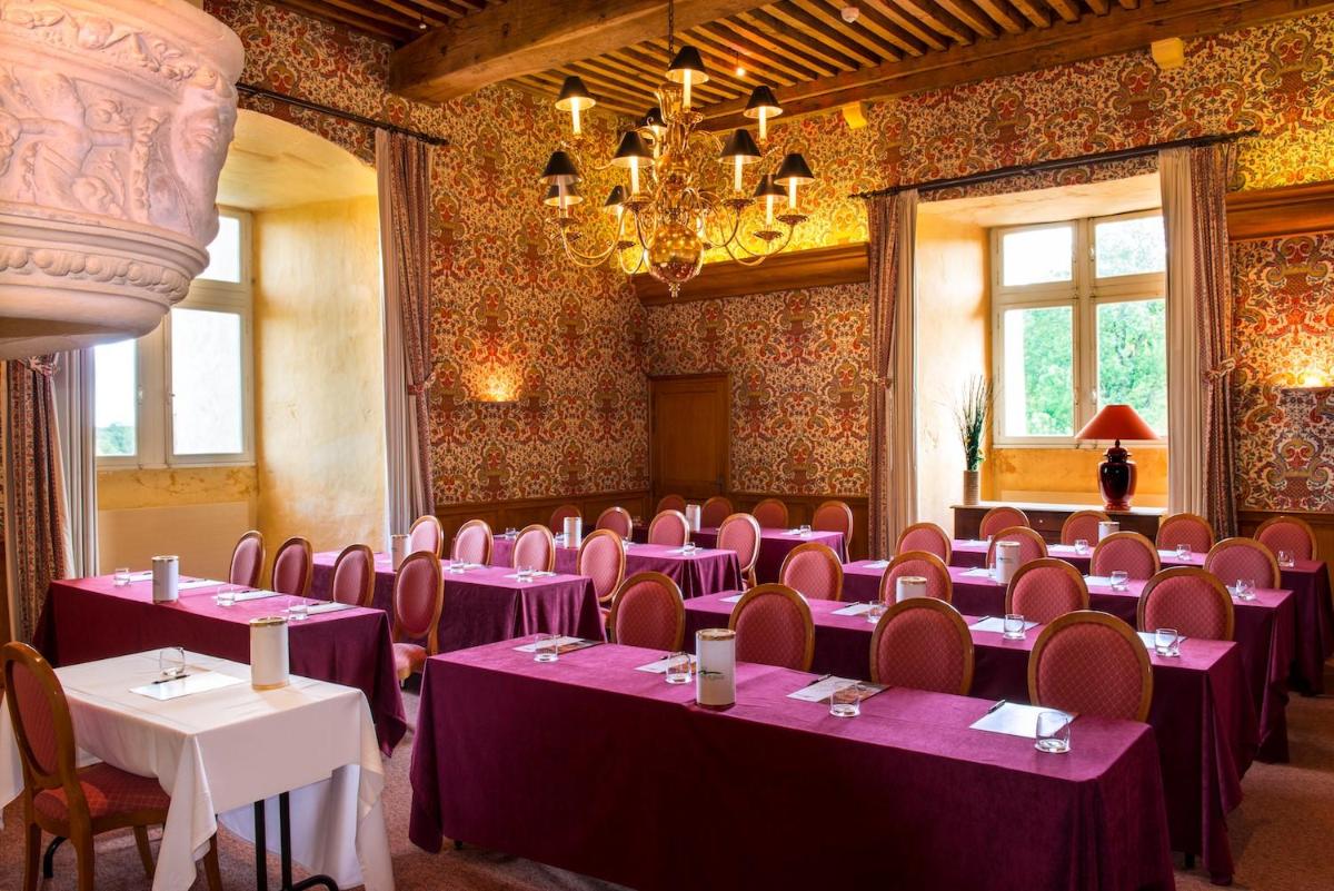 une pièce avec des tables et des chaises violettes et un lustre dans l'établissement Hôtel Golf Château de Chailly, à Chailly-sur-Armançon 49 autres photos
