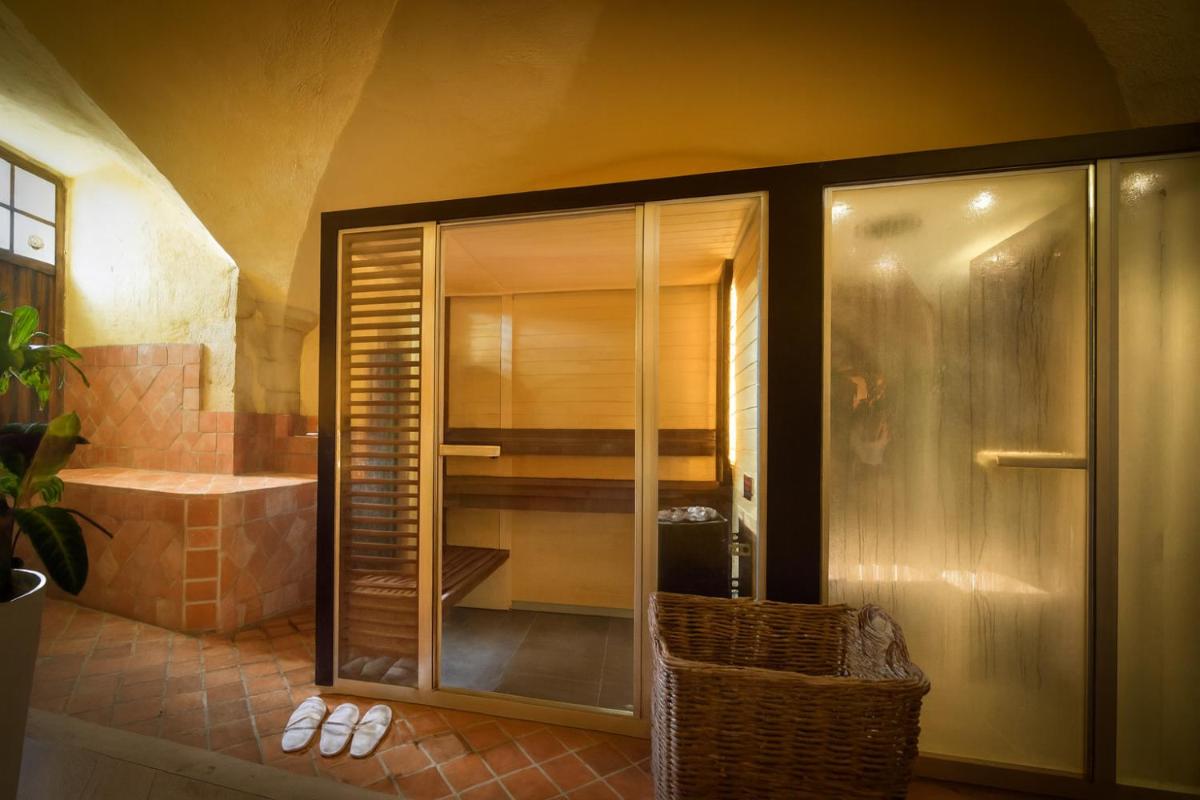 une douche en verre dans une salle de bains avec baignoire dans l'établissement Hôtel Golf Château de Chailly, à Chailly-sur-Armançon