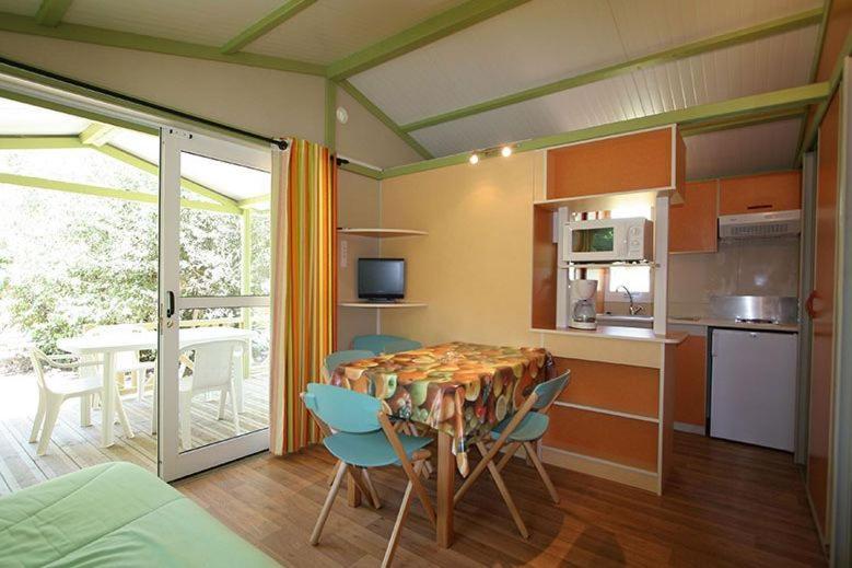 une cuisine et une salle à manger avec une table et des chaises dans l'établissement Camping La Pinède, à Calvi