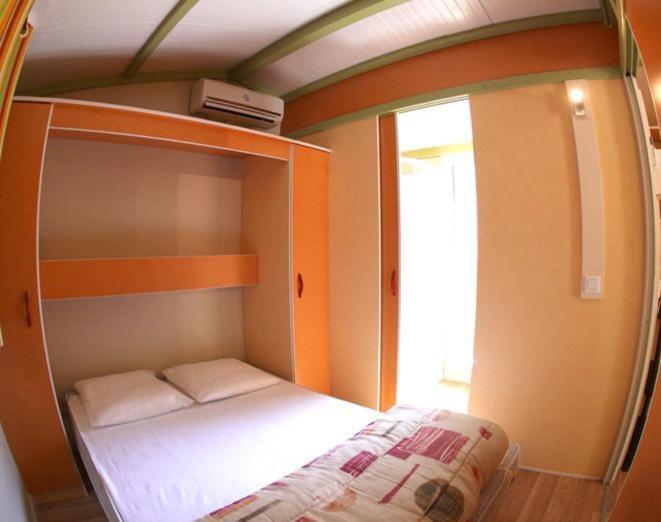 Un ou plusieurs lits dans un hébergement de l'établissement Camping La Pinède