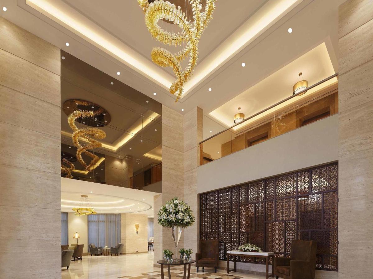 a lobby of a hotel with a chandelier at Novotel Lucknow Gomti Nagar in Lucknow