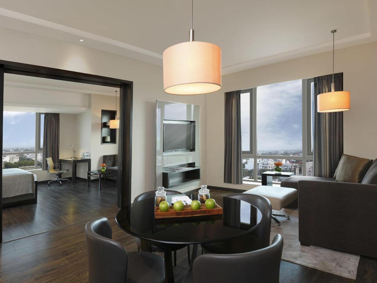 a living room with a couch and a table with fruit on it at Novotel Lucknow Gomti Nagar in Lucknow