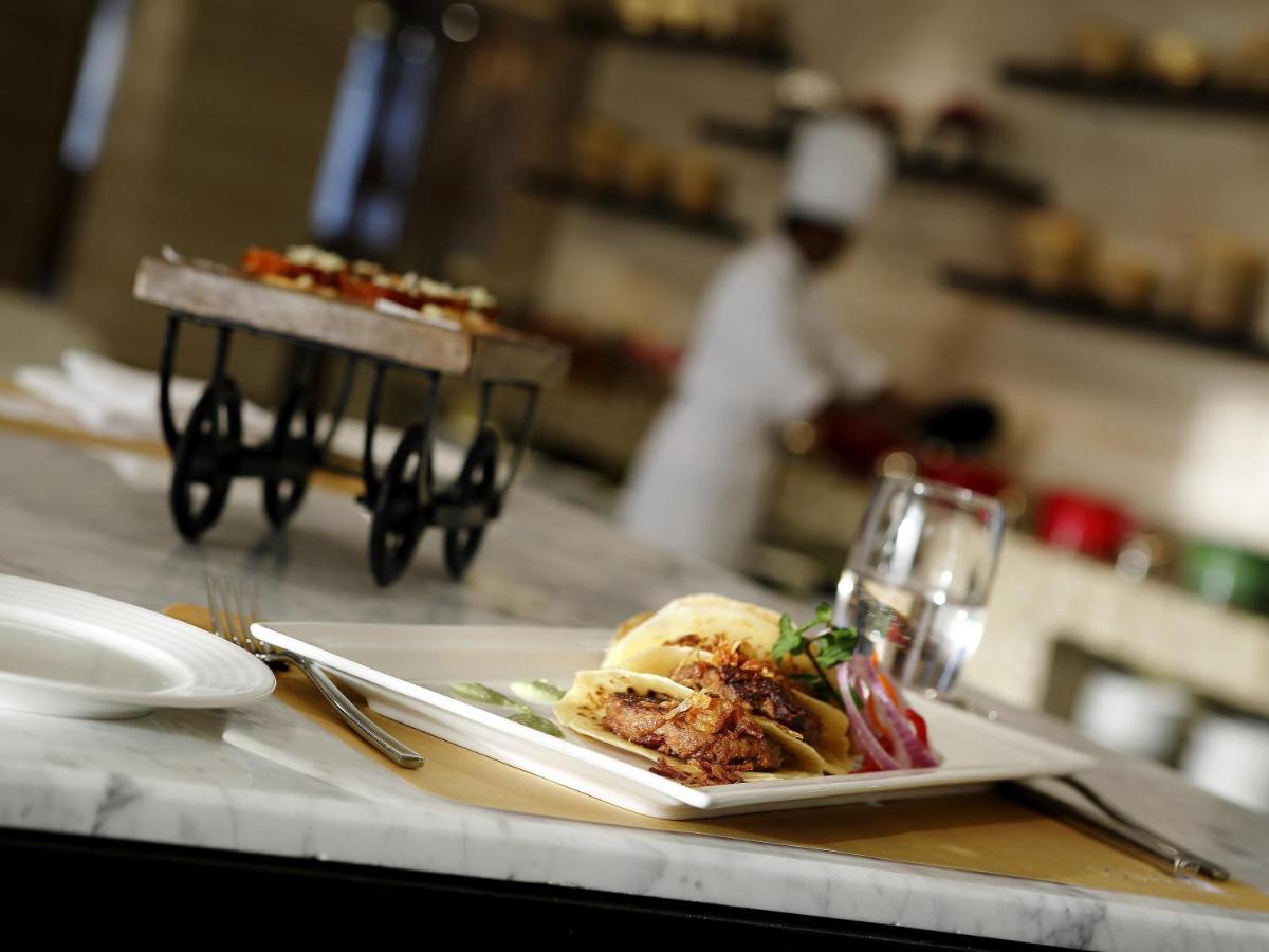 a plate of food on a counter in a restaurant at Novotel Lucknow Gomti Nagar in Lucknow