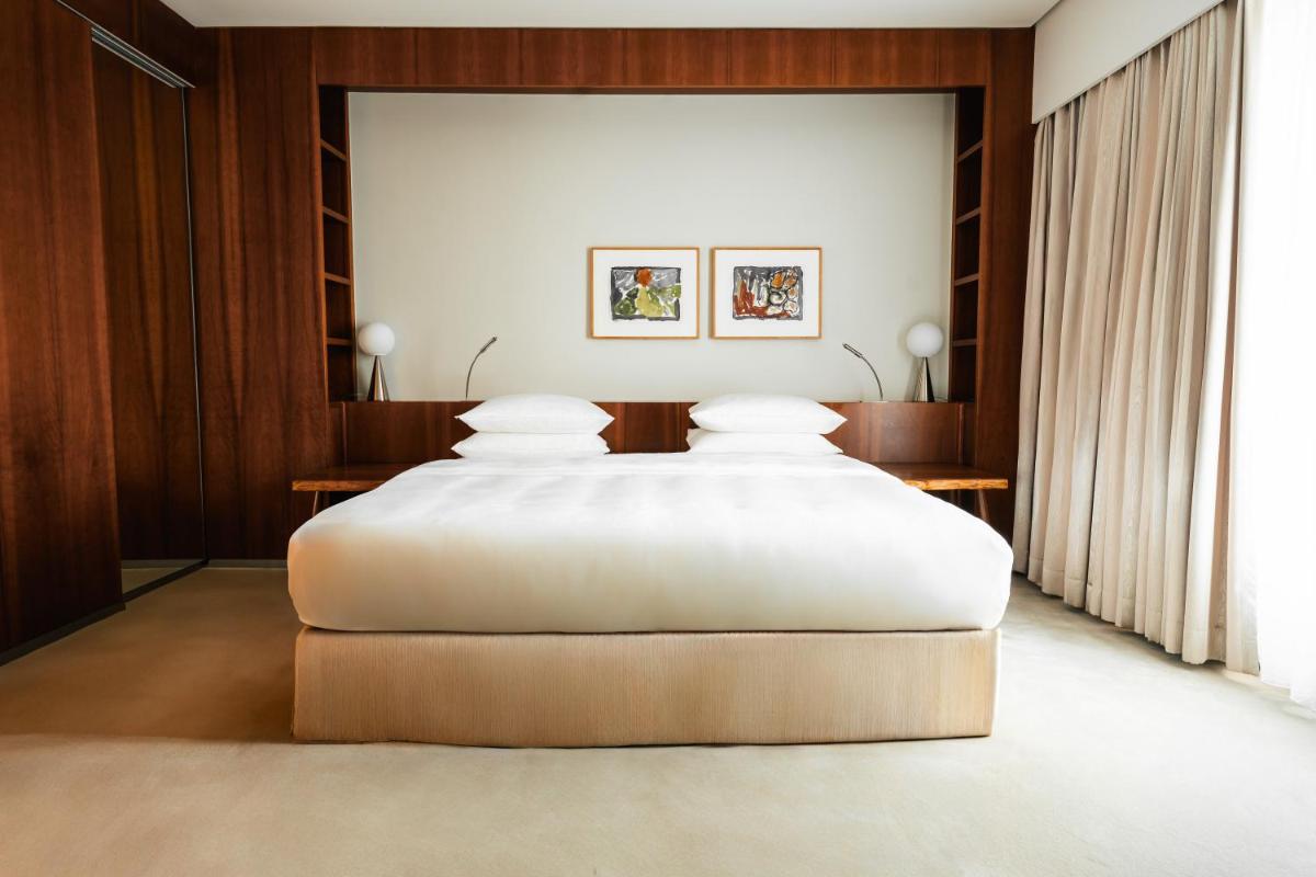 ein großes weißes Bett in einem Zimmer mit zwei Tischen in der Unterkunft Grand Hyatt Berlin in Berlin