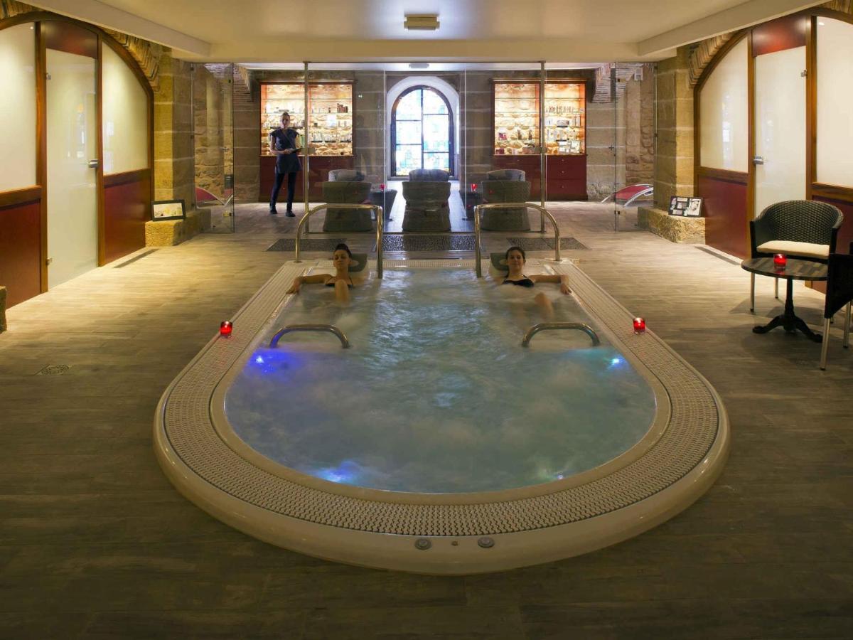 un jacuzzi avec trois personnes dedans dans un bâtiment dans l'établissement Mercure Moulins Centre Hôtel de Paris, à Moulins