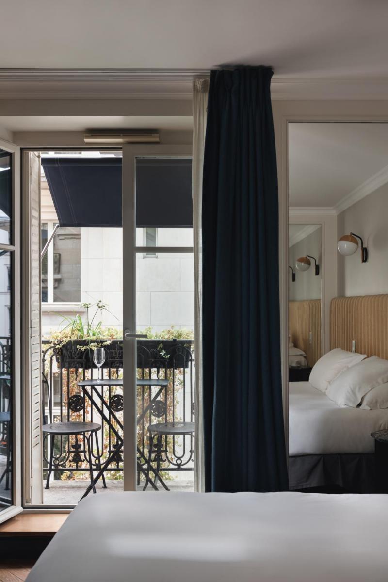 une chambre avec un lit et un balcon dans l'établissement Hotel Bachaumont, à Paris