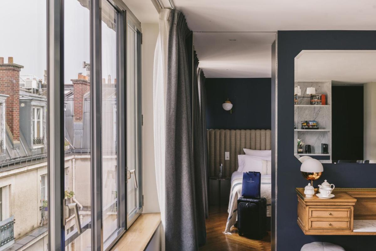 une chambre avec un lit et une grande fenêtre dans l'établissement Hotel Bachaumont, à Paris