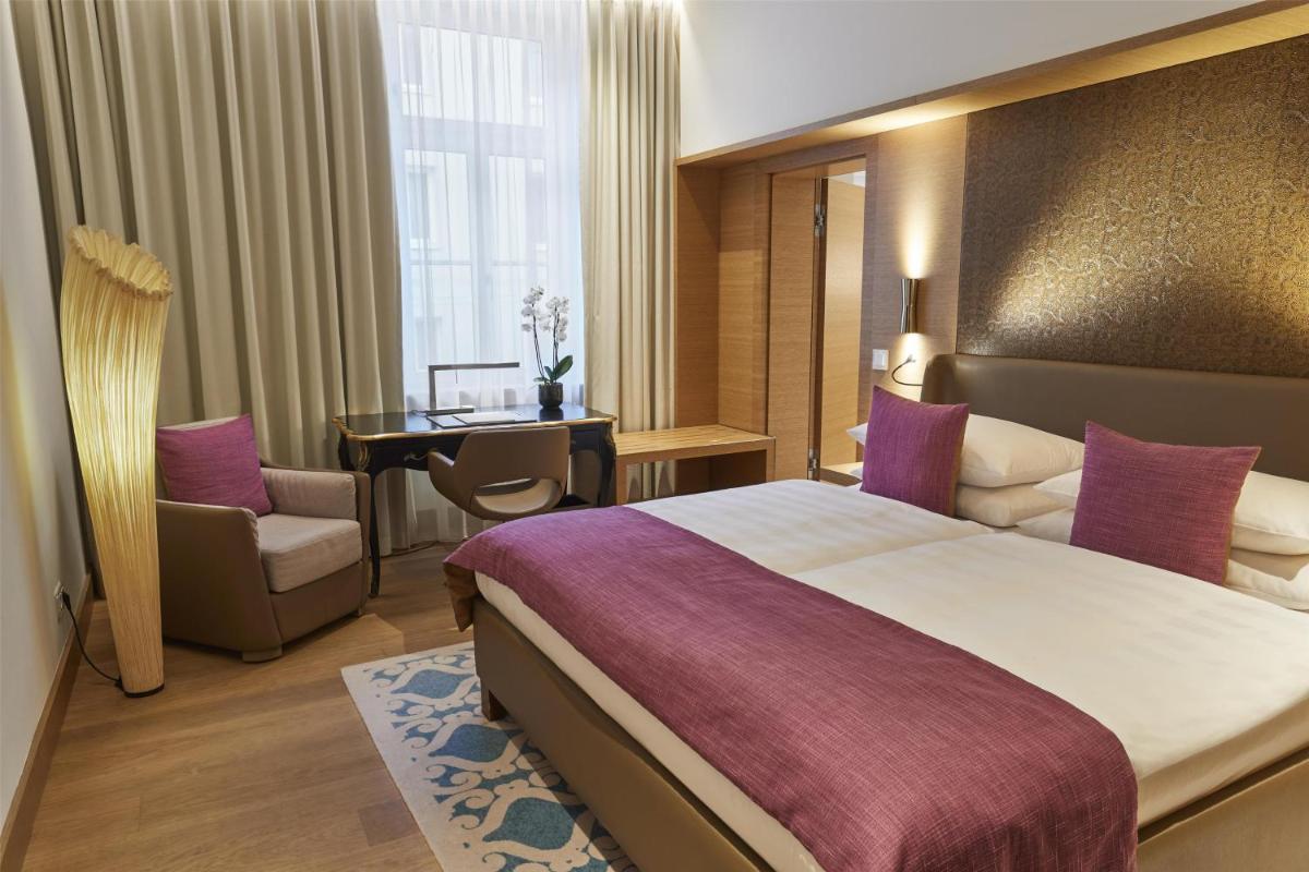 Ein Bett oder Betten in einem Zimmer der Unterkunft Vier Jahreszeiten Kempinski München