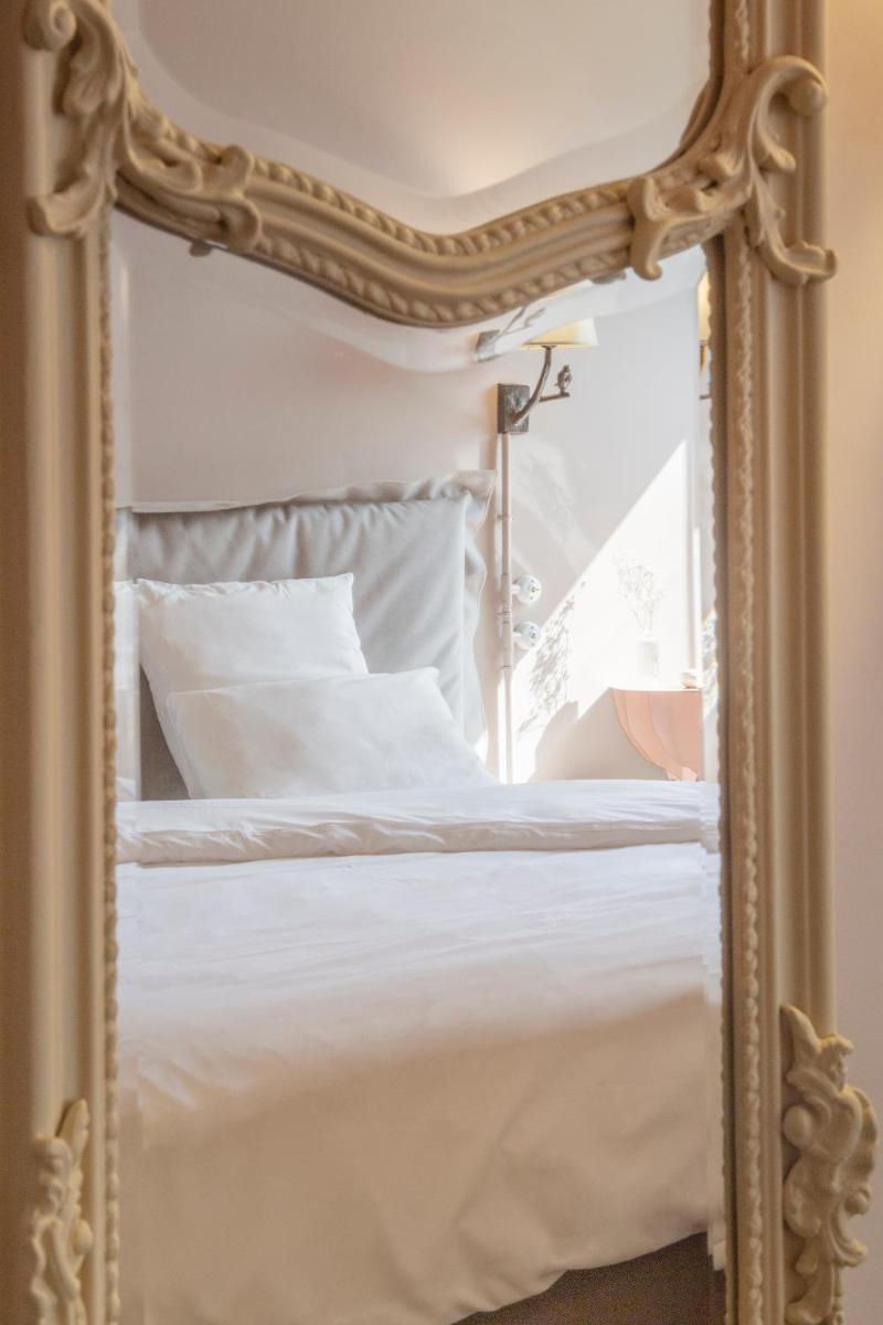 - un miroir reflétant un lit dans une chambre dans l'établissement Demeures de Campagne Parc du Coudray - Barbizon, à Le Coudray-Montceaux