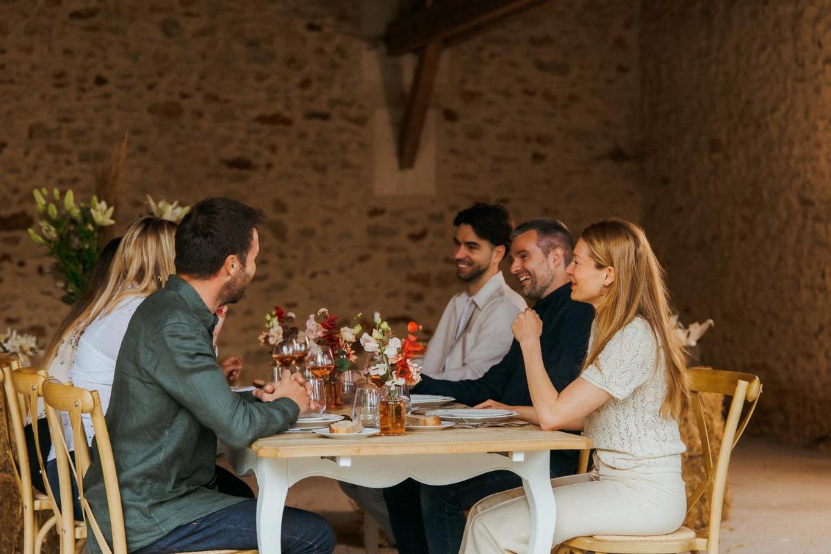 un groupe de personnes assises à une table dans l'établissement Demeures de Campagne Parc du Coudray - Barbizon, à Le Coudray-Montceaux