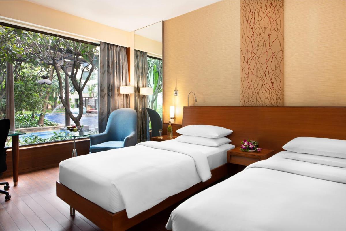 a hotel room with two beds and a window at Hyatt Pune in Pune