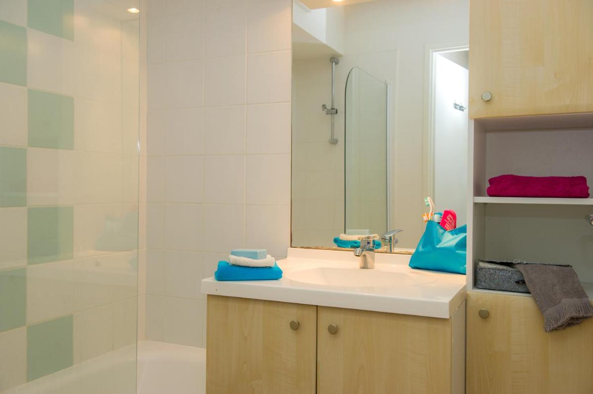 une salle de bain avec un lavabo et une douche dans l'établissement Résidence Goélia Le Cordouan, à Soulac-sur-Mer