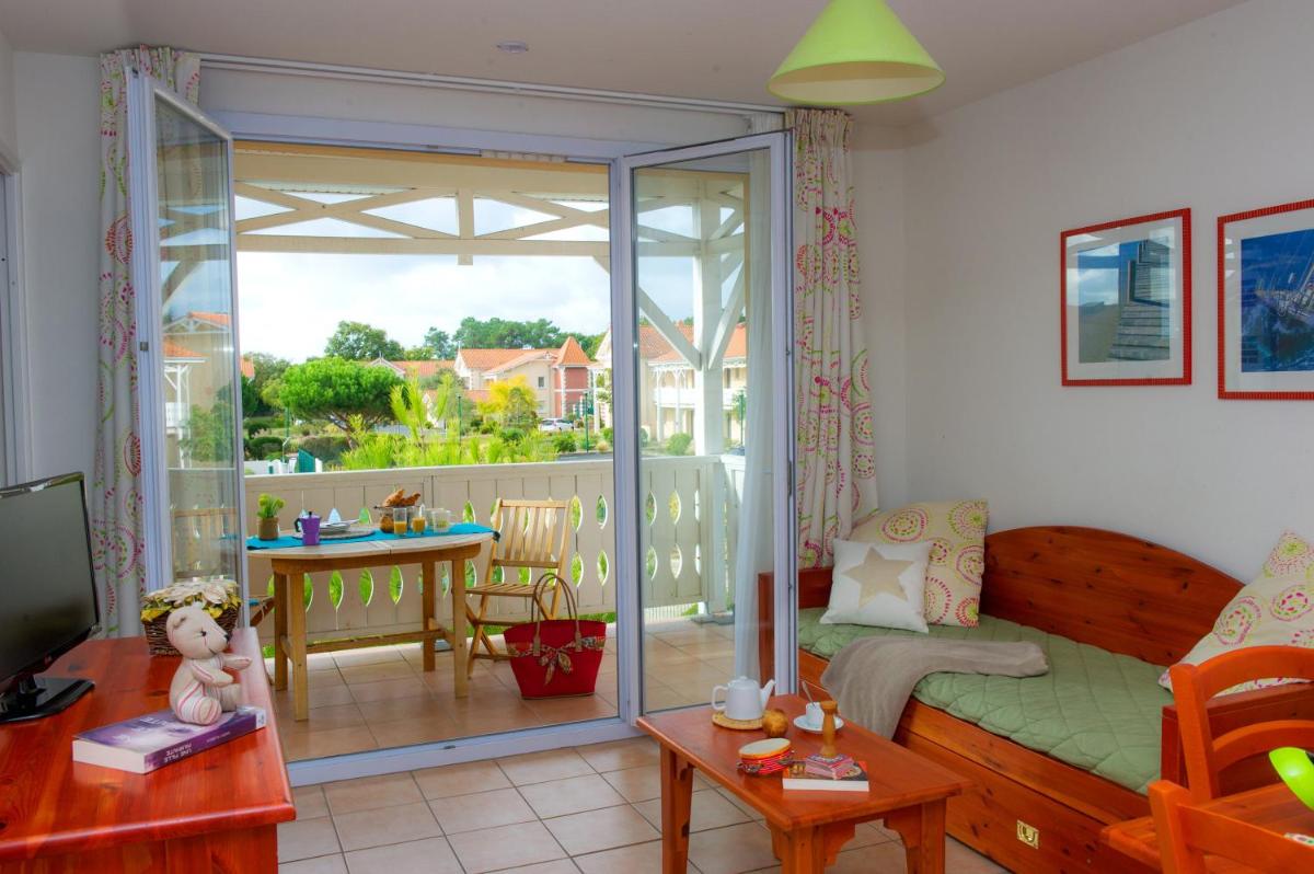 d'un salon avec un canapé et un balcon. dans l'établissement Résidence Goélia Le Cordouan, à Soulac-sur-Mer