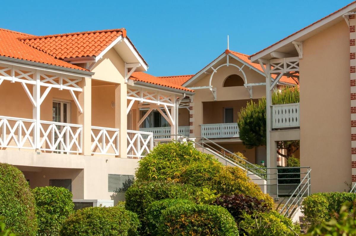 une rangée de maisons au toit orange dans l'établissement Résidence Goélia Le Cordouan, à Soulac-sur-Mer