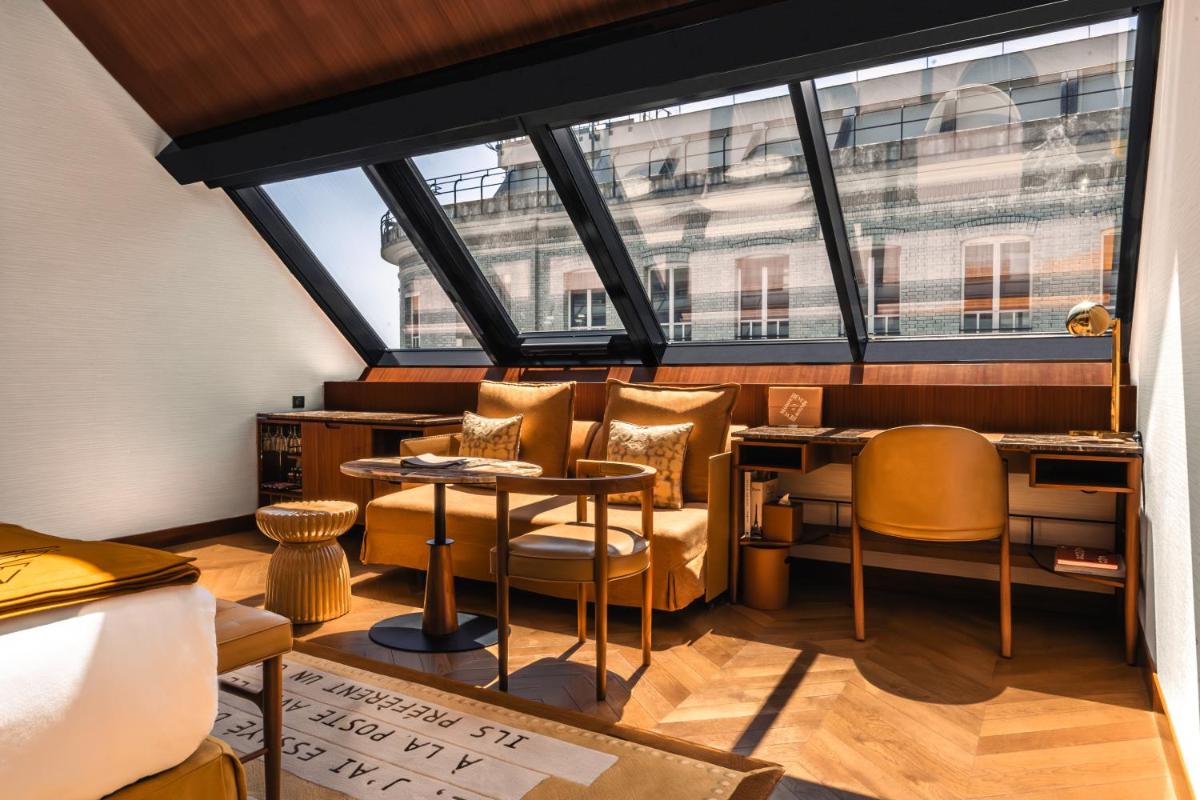 une pièce avec une table, des chaises et des fenêtres dans l'établissement Hôtel Madame Rêve, à Paris