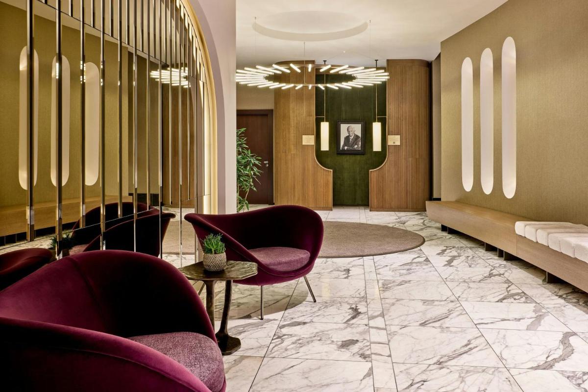 eine Lobby mit Stühlen, einer Couch und einem Tisch in der Unterkunft JW Marriott Hotel Frankfurt in Frankfurt am Main + 80 Fotos